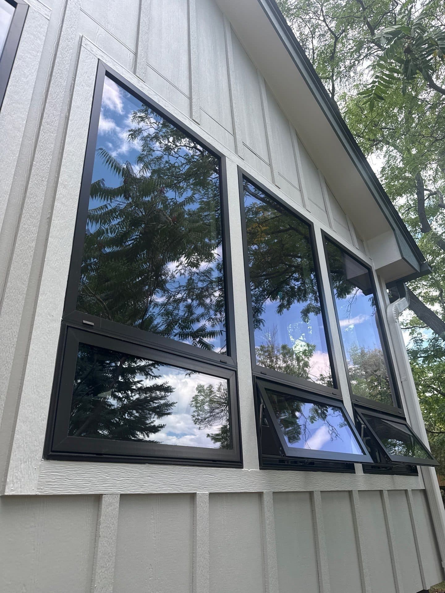 New black Pella windows set in board-and-batten siding on an Arvada, CO home